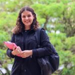 menina sorrindo com uma pasta na mão