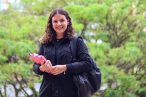 menina sorrindo com uma pasta na mão